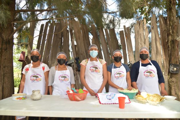 Grupo de mujeres exponiendo su receta balanceada con alimentos que ellas mismas producen.